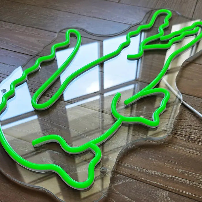 Krokodil Neon LED Schild ausgeschaltet auf Holzboden liegend, transparente Acrylplatte mit Tageslichtreflexen