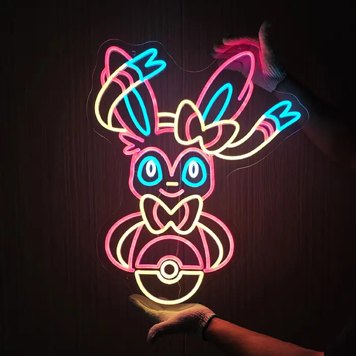 Fantasietier Neon LED Schild mit Handschuhen an die Wand gehalten, Ohren und Bänder strahlen kräftig