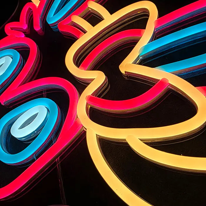 Fantasietier Neon LED Schild in Makroaufnahme: blaues Auge, rosa Kontur und gelbes Schleifenband