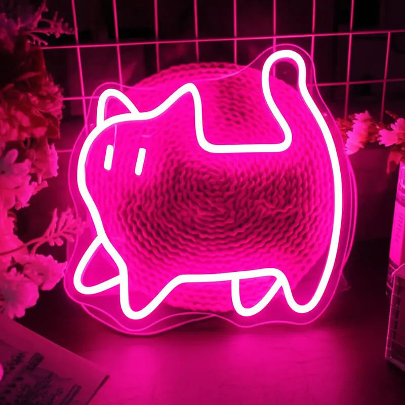 Pinke Katze Neon LED Schild steht auf einer Ablage neben Blüten und taucht die Umgebung in rosa Licht