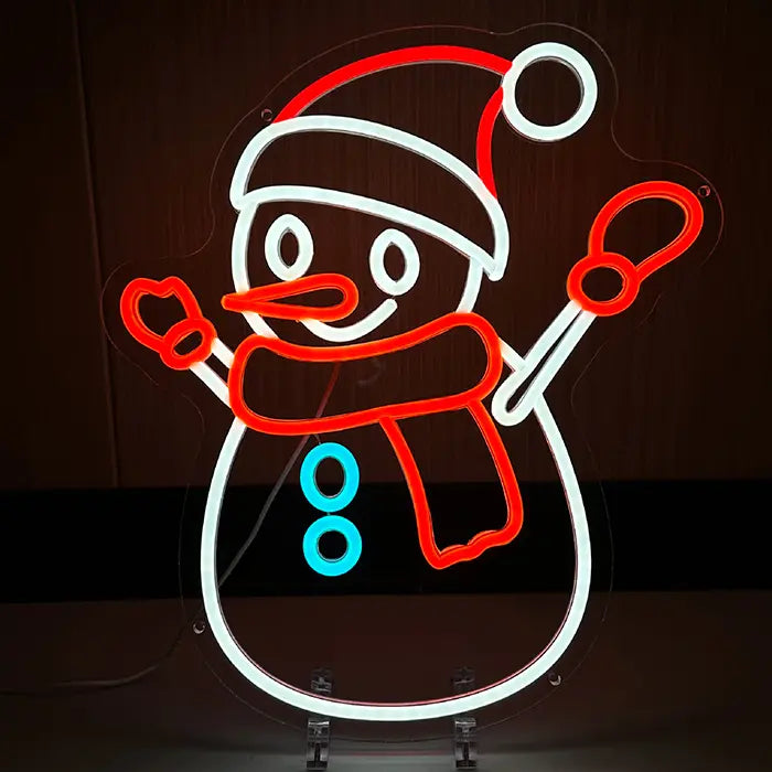 Schneemann Neon LED Schild in Nahaufnahme, leuchtend an einer dunklen Holzwand mit Mütze und Karottennase