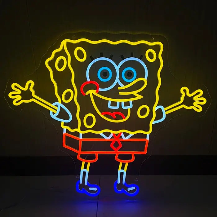 Schwammfigur Neon LED Schild leuchtet gelb an dunkler Wand, eckige Figur mit offenen Armen und breitem Grinsen