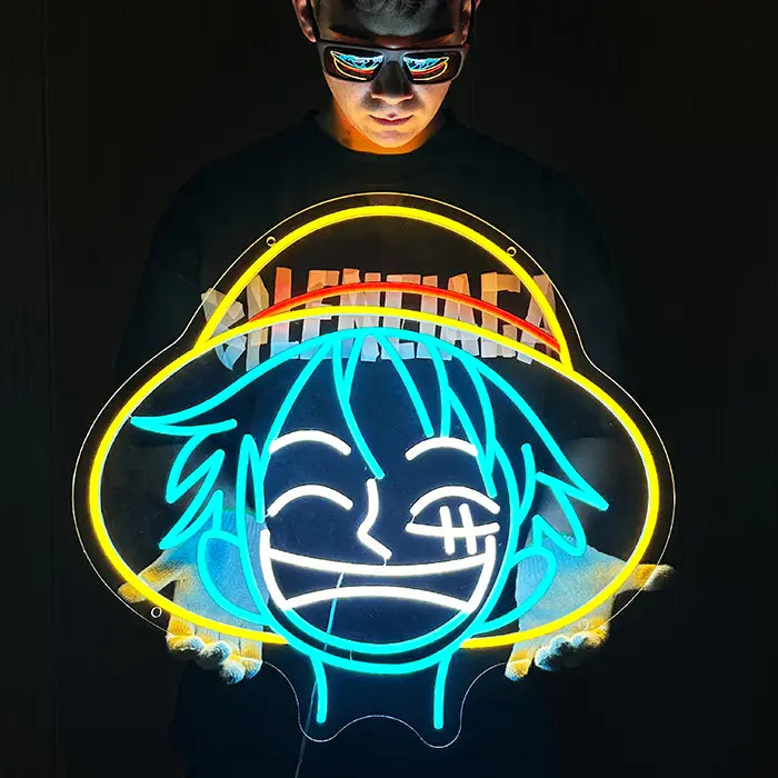 Strohhut Neon LED Schild frontal im Dunkeln gehalten, gelbe Hutlinie und rotes Band leuchten über blauem Gesicht