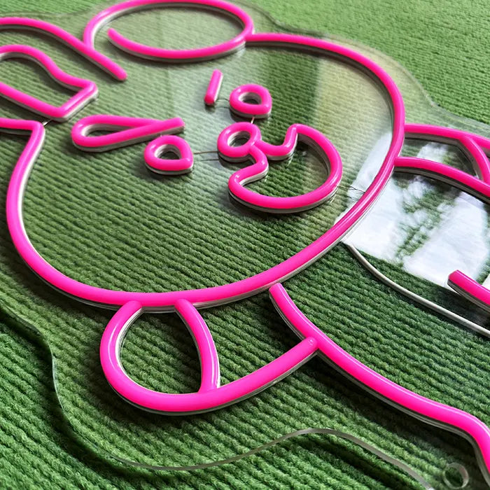 Pinker Hase Neon LED Schild, auf einer glatten Fläche stehend, Lichtreflexion darunter