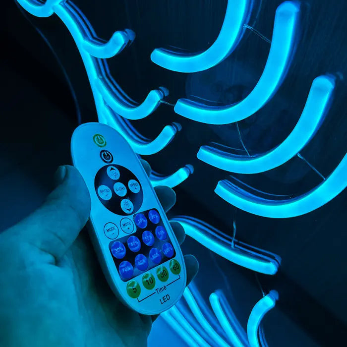 Godzilla Neon LED Sign: the remote in hand in front of the glowing neon tubing