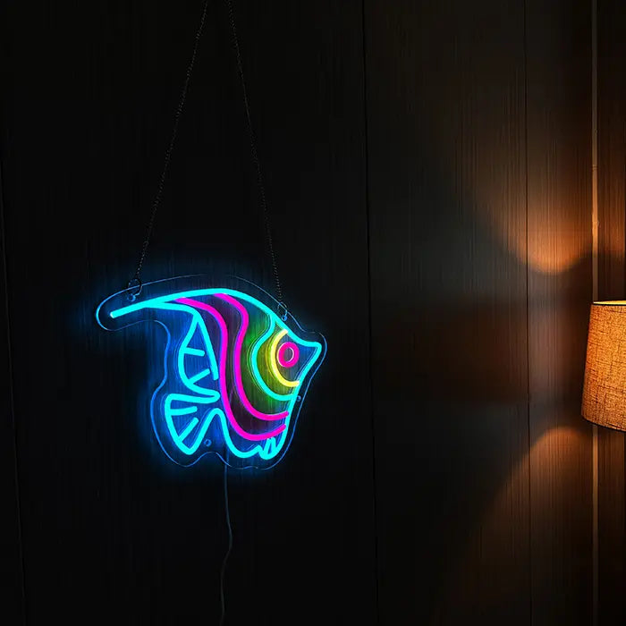 Ocean Fish Neon LED Sign hanging on a dark wooden wall, a floor lamp casting warm light beside it