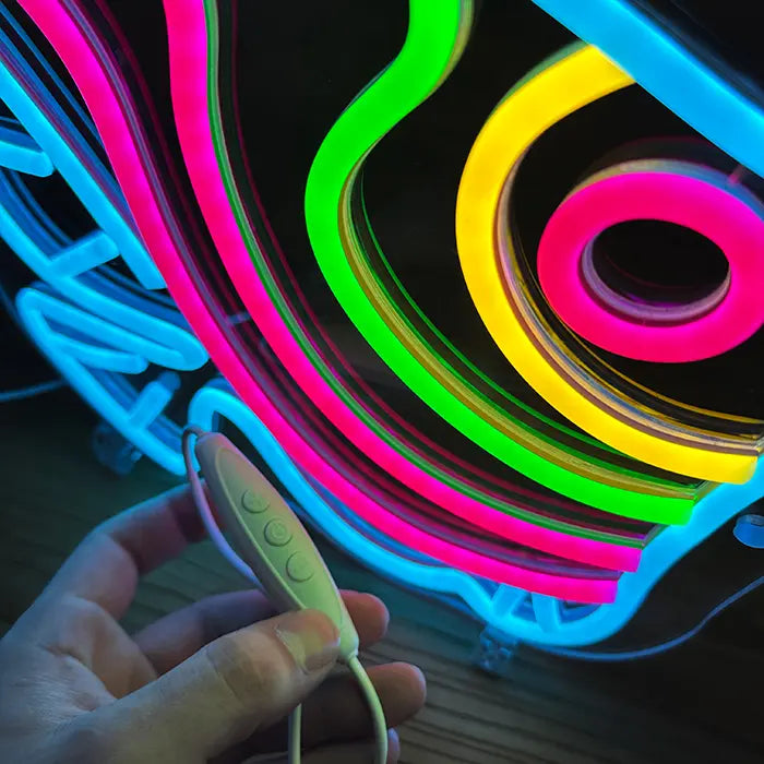 Ocean Fish Neon LED Sign in close-up, the inline dimmer resting in a hand in front of the neon lines