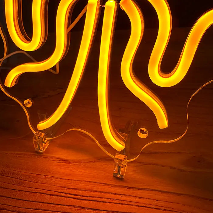 Gold Octopus Neon LED Sign in close-up, neon tubing and the stand on wood