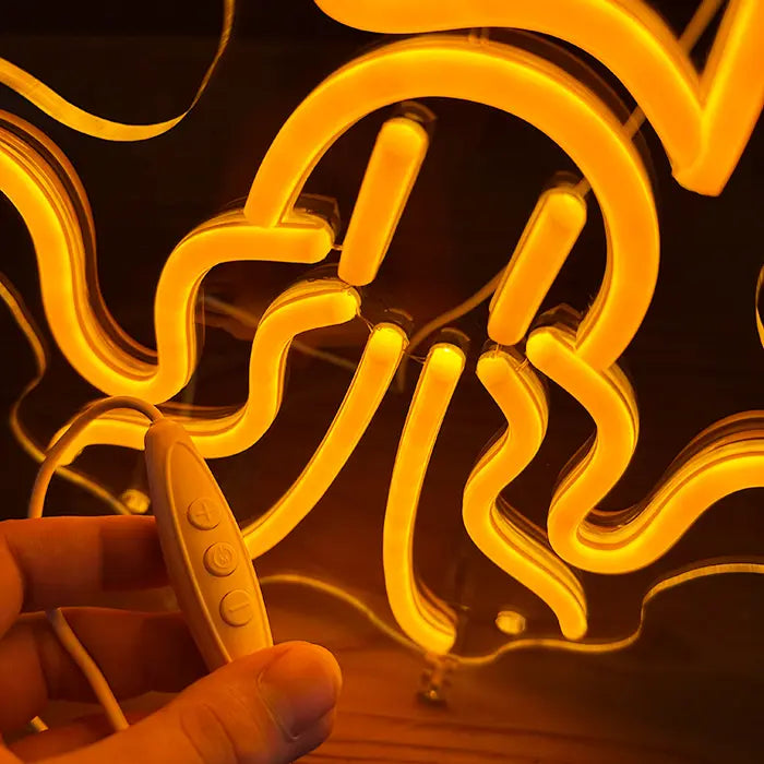 Gold Octopus Neon LED Sign in close-up, the inline dimmer resting in a hand
