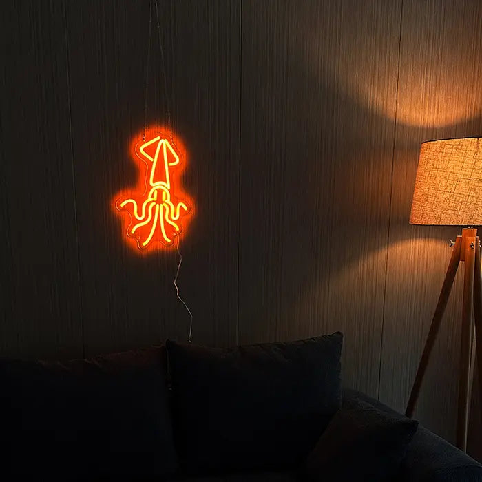 Gold Octopus Neon LED Sign on a dark wall above a sofa with cushions