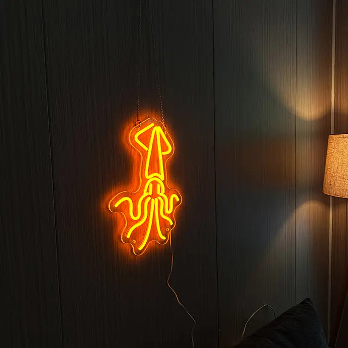 Gold Octopus Neon LED Sign hanging on a dark wooden wall with a warm floor lamp beside it