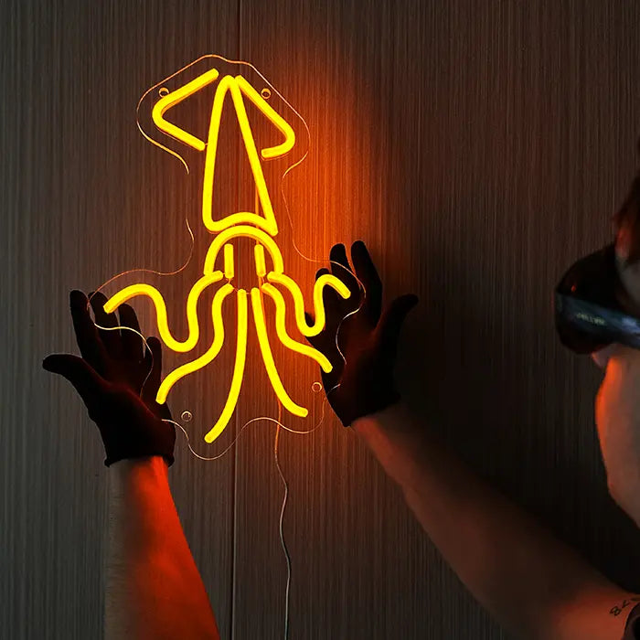Gold Octopus Neon LED Sign held against the wall with gloves and aligned