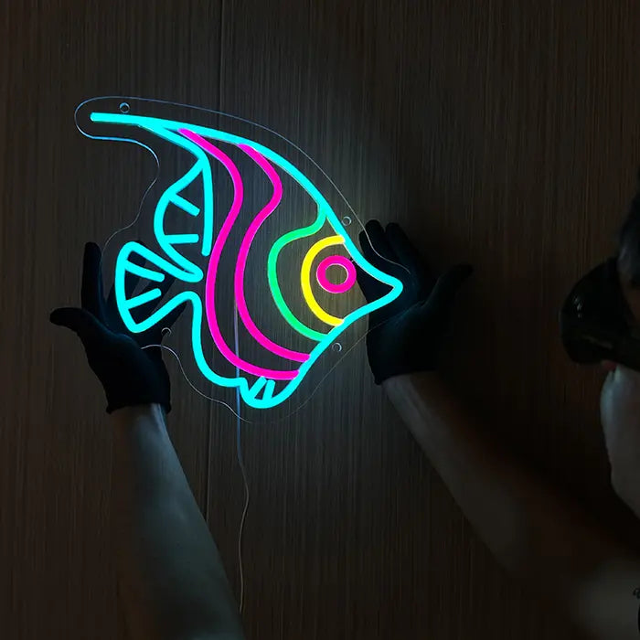 Ocean Fish Neon LED Sign held against a wooden wall with gloves and aligned