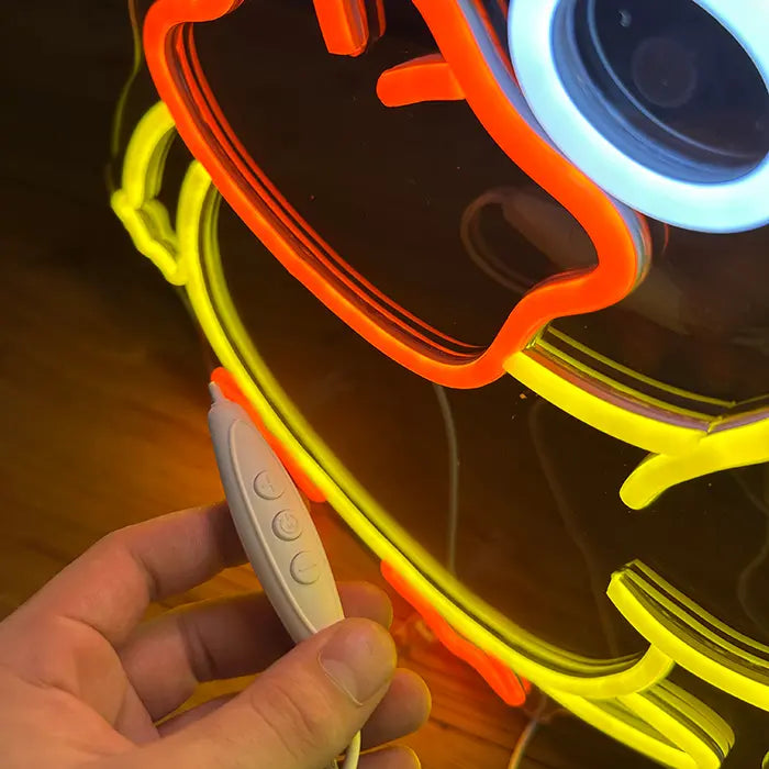 Pokémon Psyduck Middle Finger Neon LED Sign in close-up, the inline dimmer resting in a hand