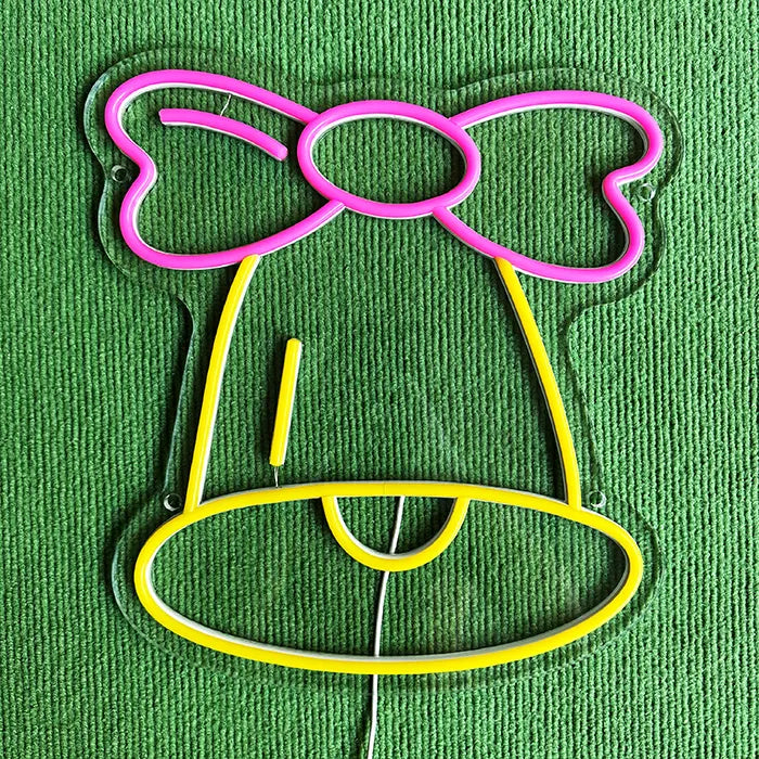 Little Bell Neon LED Sign switched off on a green surface, bow and bell as neon tubing