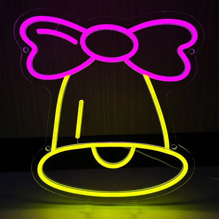Little Bell Neon LED Sign head-on against a dark background, a yellow bell with a pink bow above it