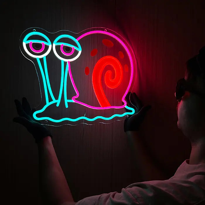 Gary the Snail Neon LED Sign held against a dark wall and aligned