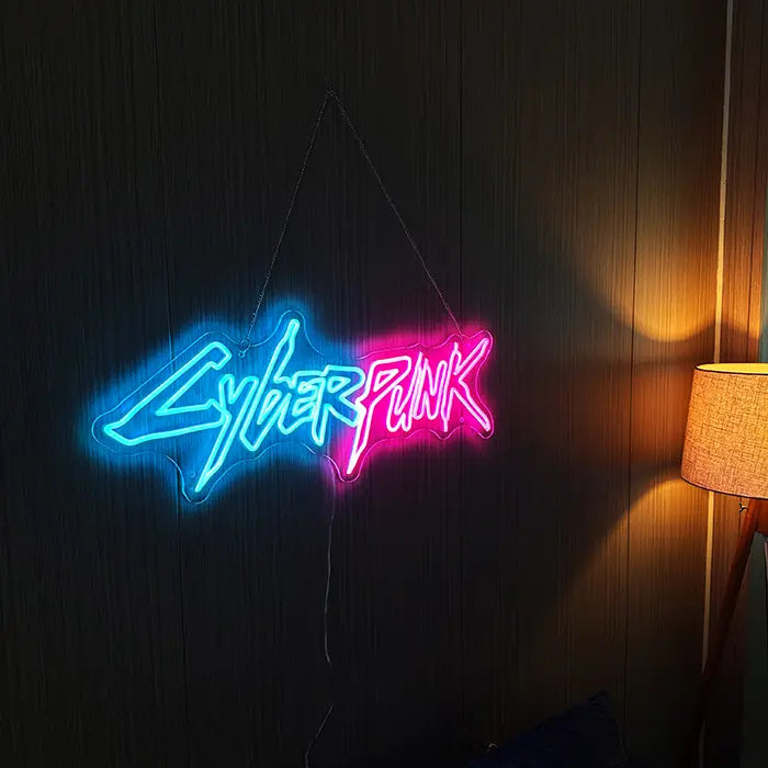 CYBERPUNK Neon LED Sign hanging on a dark wooden wall with a warm glowing floor lamp beside it
