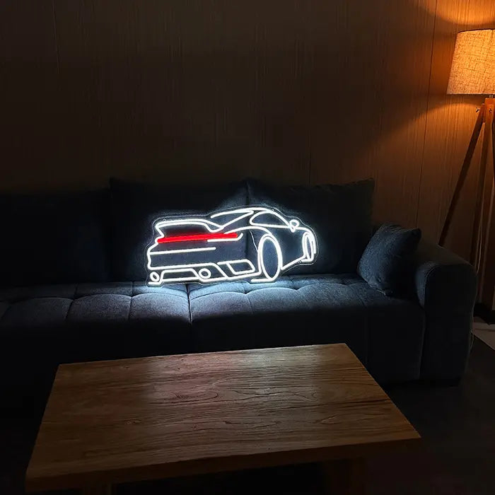 GT Sports Car Neon LED Sign set up on a dark sofa, a coffee table in front