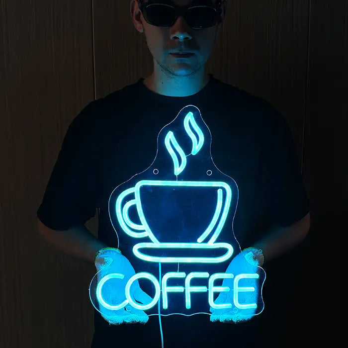 Coffee Cup Neon LED Sign held in front of the body with both hands, glowing ice blue