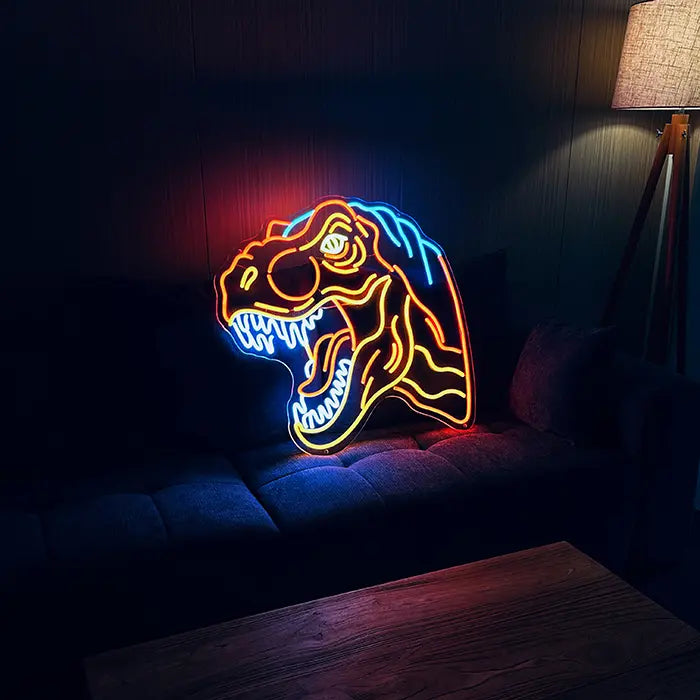 T-Rex Dino Neon LED Sign set up on a dark sofa, next to it a floor lamp