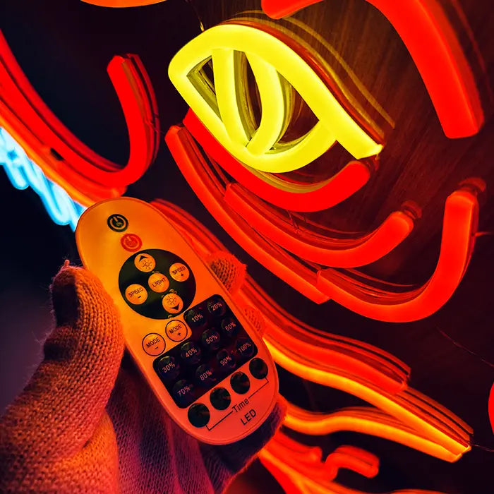 T-Rex Dino Neon LED Sign in close-up with the remote control in hand in front of the yellow eye