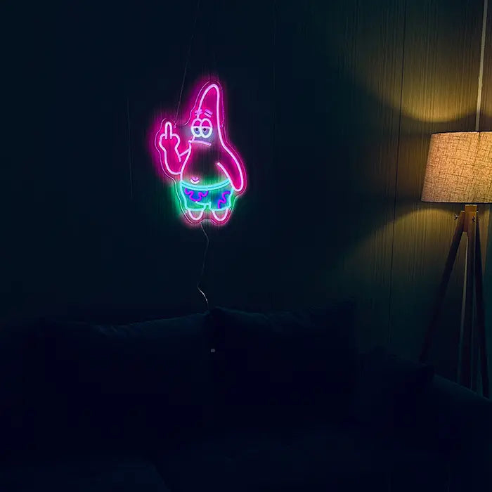 Patrick Middle Finger Neon LED Sign on a dark wall in the living room, next to it a floor lamp