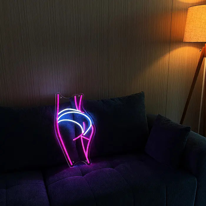 Sexy Boogie Neon LED Sign set up on a dark sofa, next to it a floor lamp