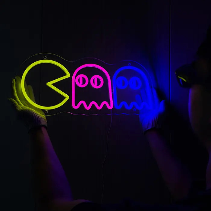 Retro Ghosts Neon LED Sign being lined up on the wall, a person in gloves holds it in place