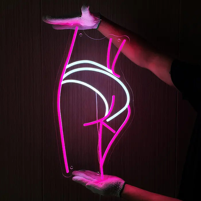 Sexy Boogie Neon LED Sign being held against a dark wooden wall with gloves