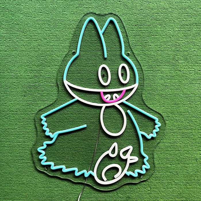 Pokémon Munchlax Neon LED Sign switched off on a green carpet, turquoise and white silicone tubes on clear acrylic