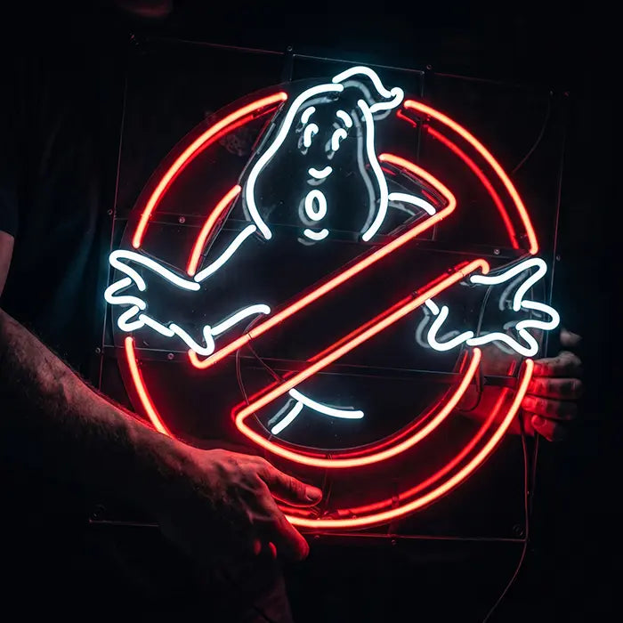 Ghostbusters Logo Neon LED Schild in Nahaufnahme in zwei Händen, klare Acrylplatte hinter den Neon-Linien
