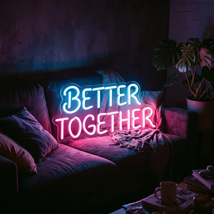 Better Together Neon LED Sign in blue-pink on a sofa with cushions