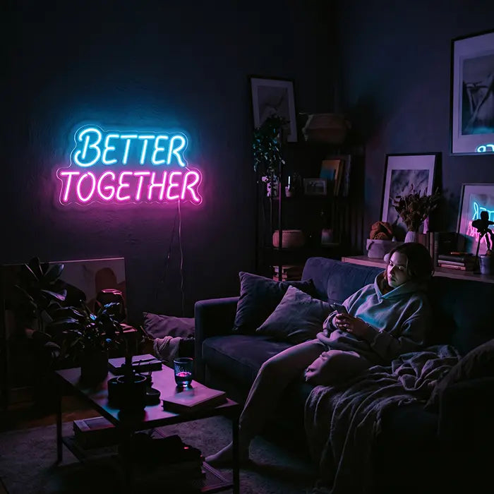 Better Together Neon LED Sign in blue-pink above a sofa, a woman with a phone on it
