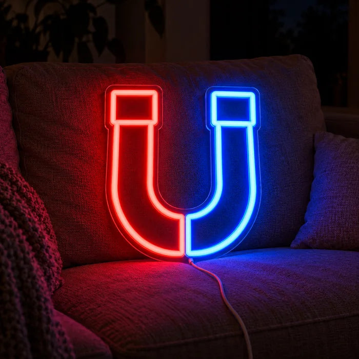 Magnetic Attraction Neon LED Sign on a cosy sofa between cushions and a throw