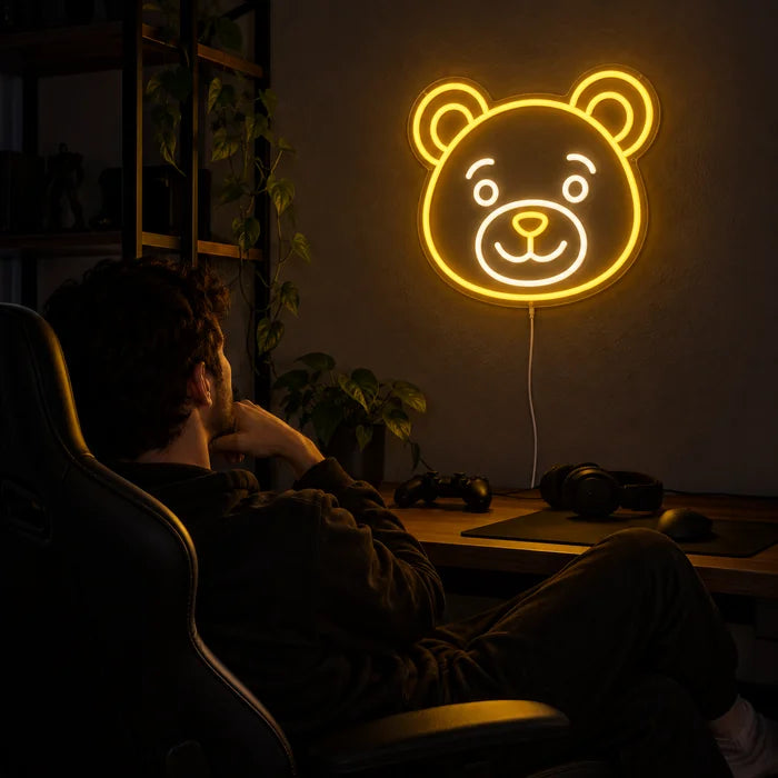 Bear Smile Neon LED Sign above a gaming desk, a gamer in a gaming chair in front of it