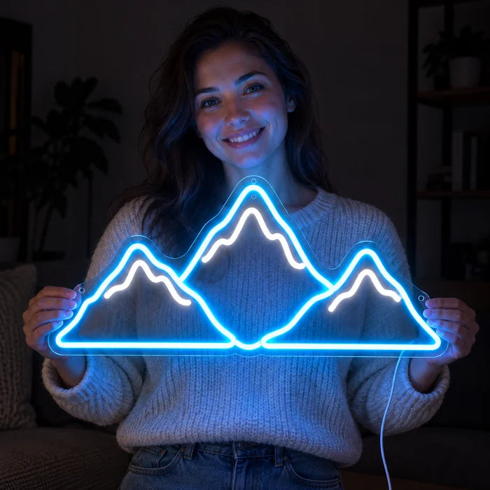 Mountain Silhouette Neon LED Sign held by a smiling woman against a dark background