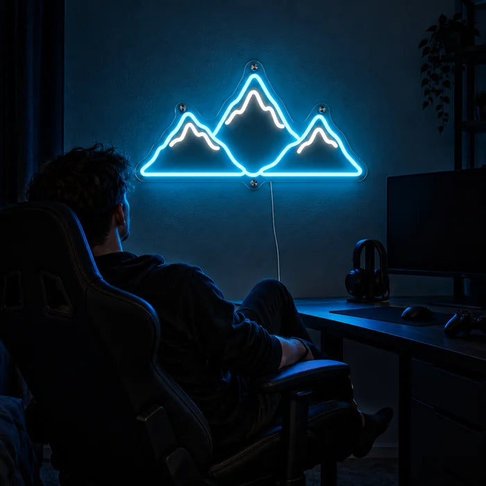 Mountain Silhouette Neon LED Sign above a gaming desk, a gamer in a gaming chair in front of it