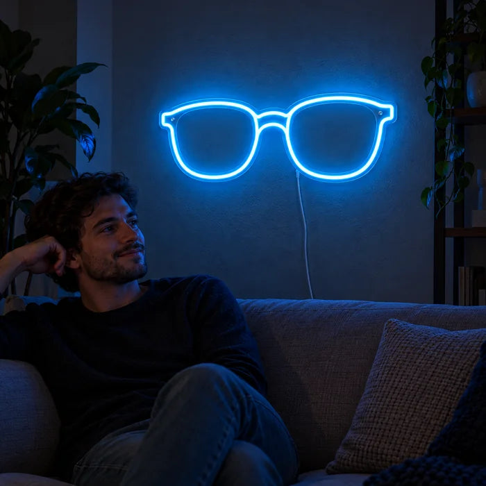 Blue Glasses Neon LED Sign on a living room wall, a person relaxing on the sofa in front of it