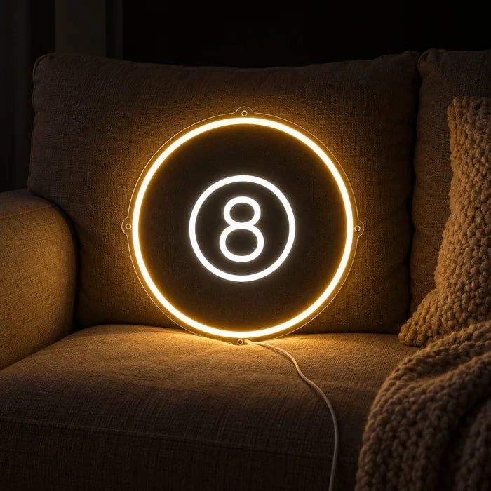 Black Eight Ball Neon LED Sign on a cosy sofa between cushions and a throw