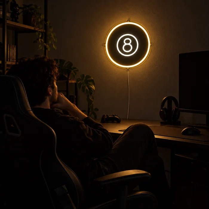 Black Eight Ball Neon LED Sign above a gaming desk, a gamer in a gaming chair in front of it