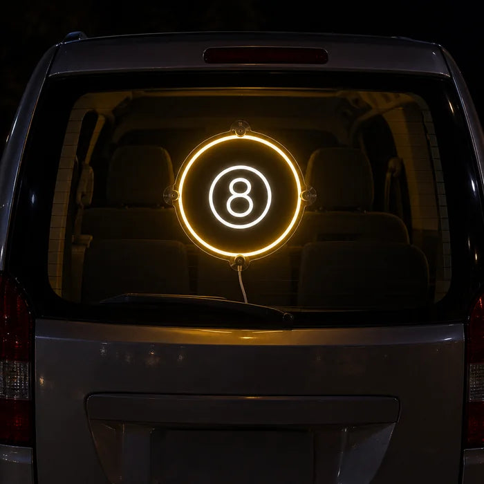 Black Eight Ball Neon LED Sign on the rear window of a car at night
