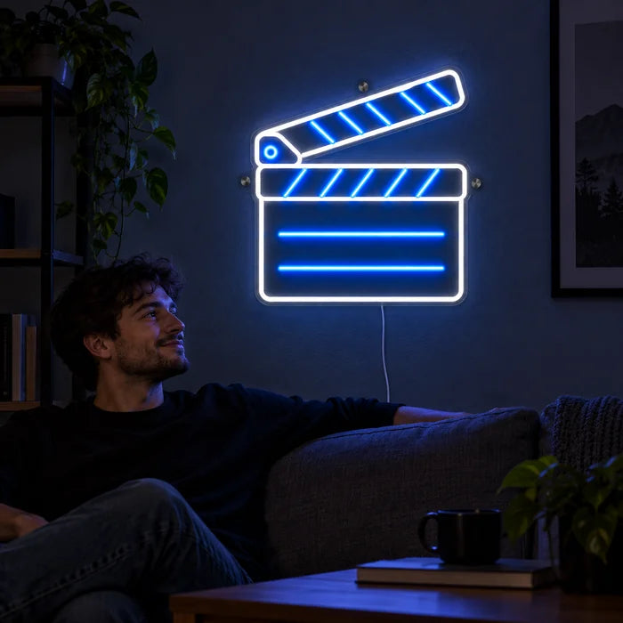 Klaket neon LED tabela, oturma odası duvarında, önünde kanepede dinlenen bir kişi