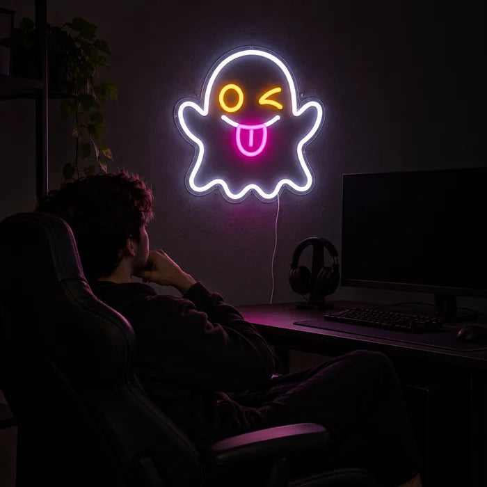 Cheeky Ghost Neon LED Sign above a gaming desk, a gamer in a gaming chair in front of it