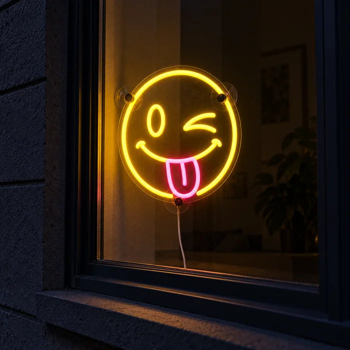 Cheeky Smiley Neon LED Sign in a window, seen from the street at night
