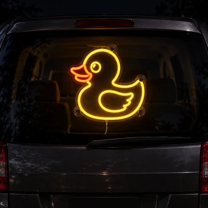 Yellow Duck Neon LED Sign on the rear window of a car at night