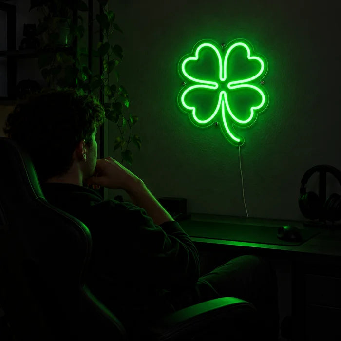 Neon LED-skilt Lykkekløver over gamingskrivebordet, foran en spiller i gamingstolen