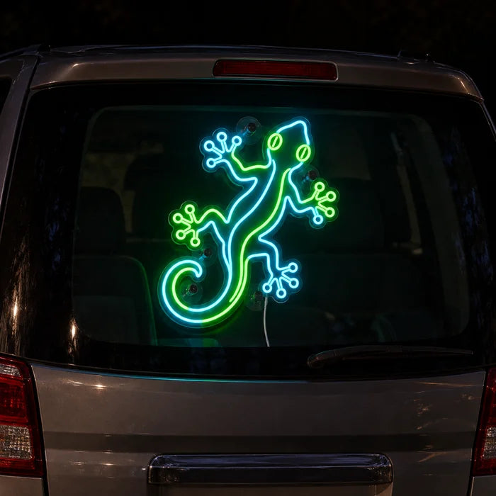 Green Gecko Neon LED Sign on the rear window of a car at night