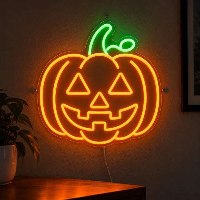 Halloweengræskar neon LED skilt lysende på en mørk væg, nærbillede med tilslutningskabel