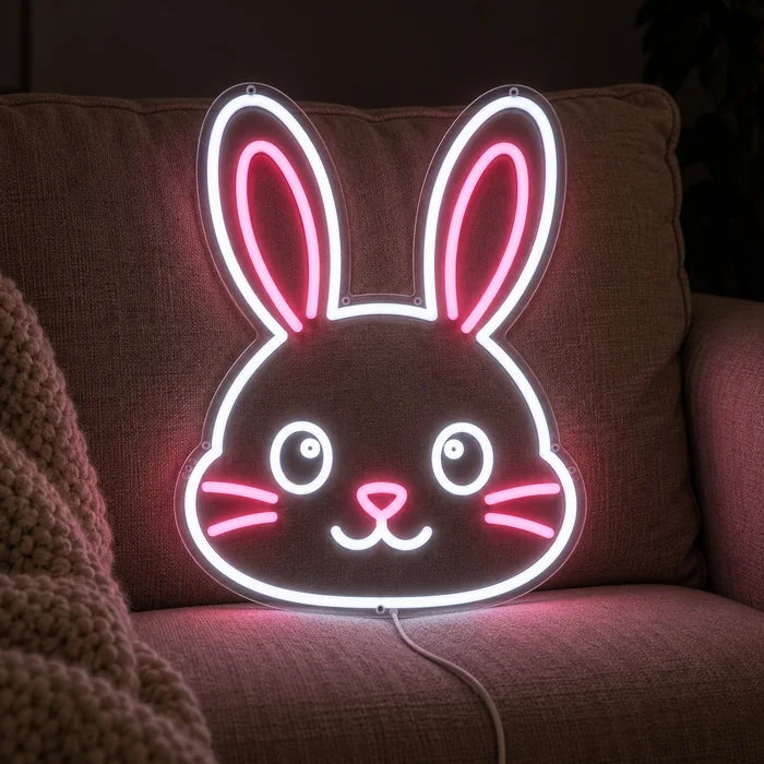 Pupun kasvot neon LED -kyltti kodikkaalla sohvalla tyynyjen ja huovan välissä